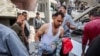EDITORS NOTE: Graphic content / TOPSHOT - Um homem carrega o corpo de uma criança que foi resgatada dos escombros após os bombardeamentos israelitas na casa de quatro andares da família Muqat, no bairro de Zarqa, no norte da cidade de Gaza, em 26 de outubro de 2024