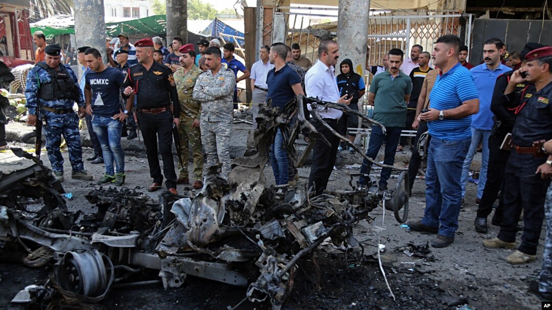 Iraqi security forces and civilians inspect the site of a deadly car bomb explosion, in Baghdad, Iraq, May 30, 2017.