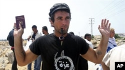 International activist Vittorio Arrigoni, from Italy, holds his passport during a protest against the Israeli siege on Gaza, in Gaza City (File 2008)