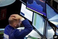 El especialista financiero Meric Greenbaum muestra su sorpresa ante la caída de acciones en la Bolsa de Valores de Nueva York, el martes 30 de enero de 2018.