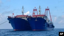 In this photo provided by the National Task Force-West Philippine Sea, Chinese vessels are moored at Whitsun Reef, South China Sea on March 27, 2021. 