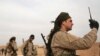 FILE - A Syrian Democratic Forces (SDF) fighter carries a walkie talkie as he stands with his fellow fighters during an offensive against Islamic State militants in northern Raqqa province, Syria February 8, 2017.