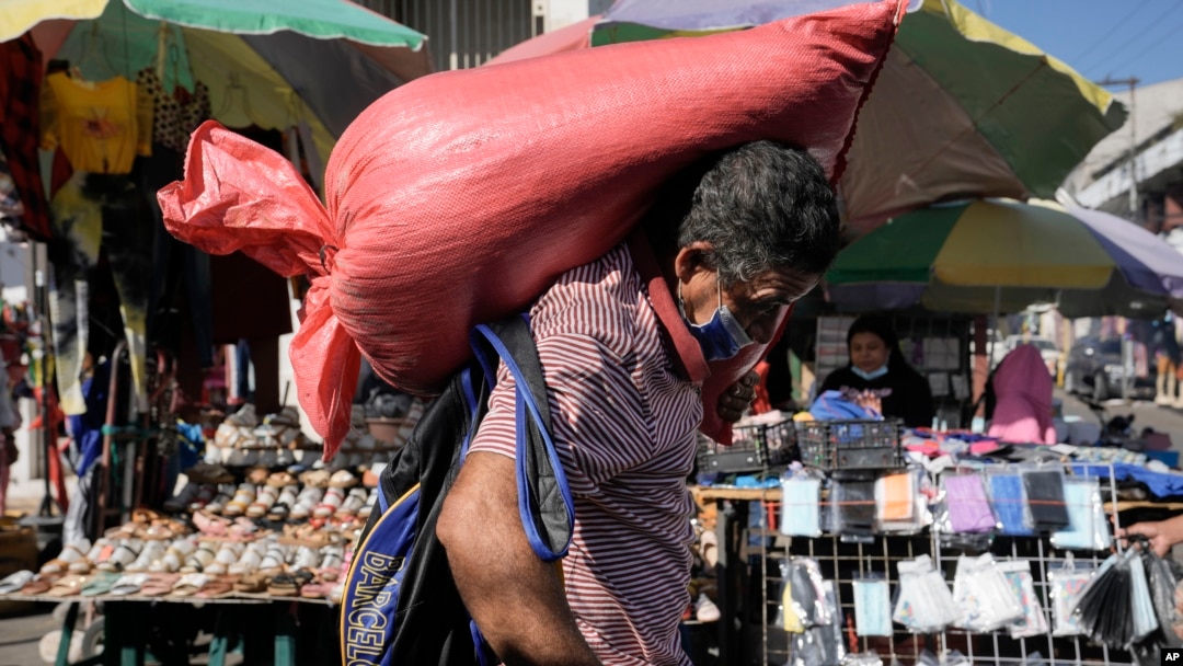 ARCHIVO - Un hombre carga un saco de maíz en el mercado de Comayaguela, en las afueras de Tegucigalpa, días después de las elecciones generales en Honduras, el 30 de noviembre de 2021. AP