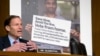 Sen. Richard Blumenthal, D-Conn., speaks next to a poster depicting an online ad that attempted to suppress votes as Facebook general counsel Colin Stretch, Twitter acting general counsel Sean Edgett and Google information security director Richard Salgado testify before a Senate subcommittee on Capitol Hill in Washington, Oct. 31, 2017, on more signs from tech companies of Russian election activity.