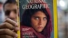 Inam Khan, owner of a book store, shows a copy of a National Geographic magazine featuring a photo of Afghan refugee Sharbat Gulla, now 46 and in police custody in Pakistan, from his collection in Islamabad, Pakistan, Oct. 26, 2016.