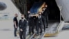 The coffin of one of the six humanitarian aid workers from the French NGO ACTED killed by gunmen in a Niger, is carried out of a military transport plan during a ceremony at Orly Airport, south of Paris, Aug. 14, 2020.