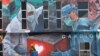 A worker adds finishing touches to giant mural tribute to front-line workers in the COVID-19 pandemic outside a hospital in Kuala Lumpur, Malaysia, on Jan. 21, 2021.
