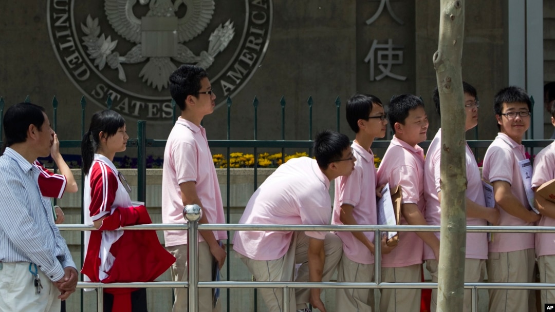 FILE -- In this May 2012 file photo, Chinese students wait outside the U.S. Embassy for their visa application interviews in Beijing, China. 
