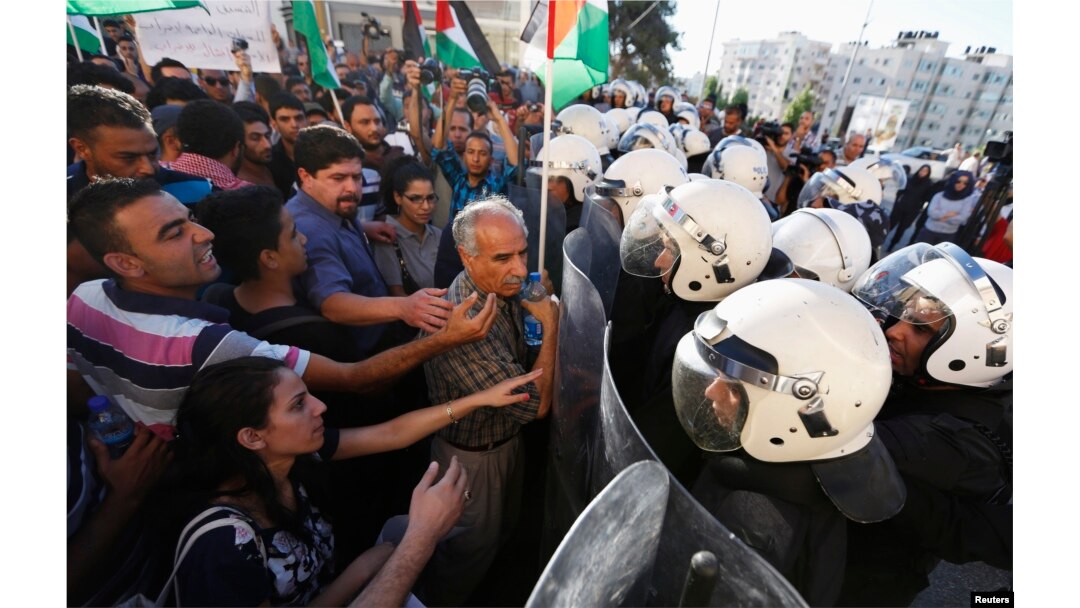 Protesters argue with Palestinian riot police during a protest against security coordination between Palestinian authority and Israel, in the West Bank city of Ramallah, June 23, 2014.