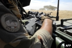 FILE - A soldier of France’s Barkhane mission holds a weapon as he patrols in central Mali, in the border zone with Burkina Faso and Niger, Nov. 01, 2017.