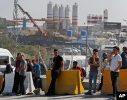 FILE - Workers gather at the entrance of Istanbul new airport construction site in Istanbul, Sept.15, 2018.