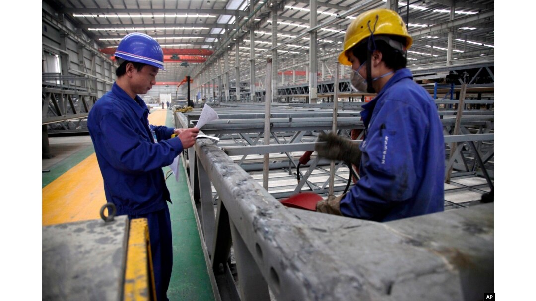 FILE - workers look over building beams at the Broad Sustainable Building Co. in Yueyang in central China's Hunan Province.