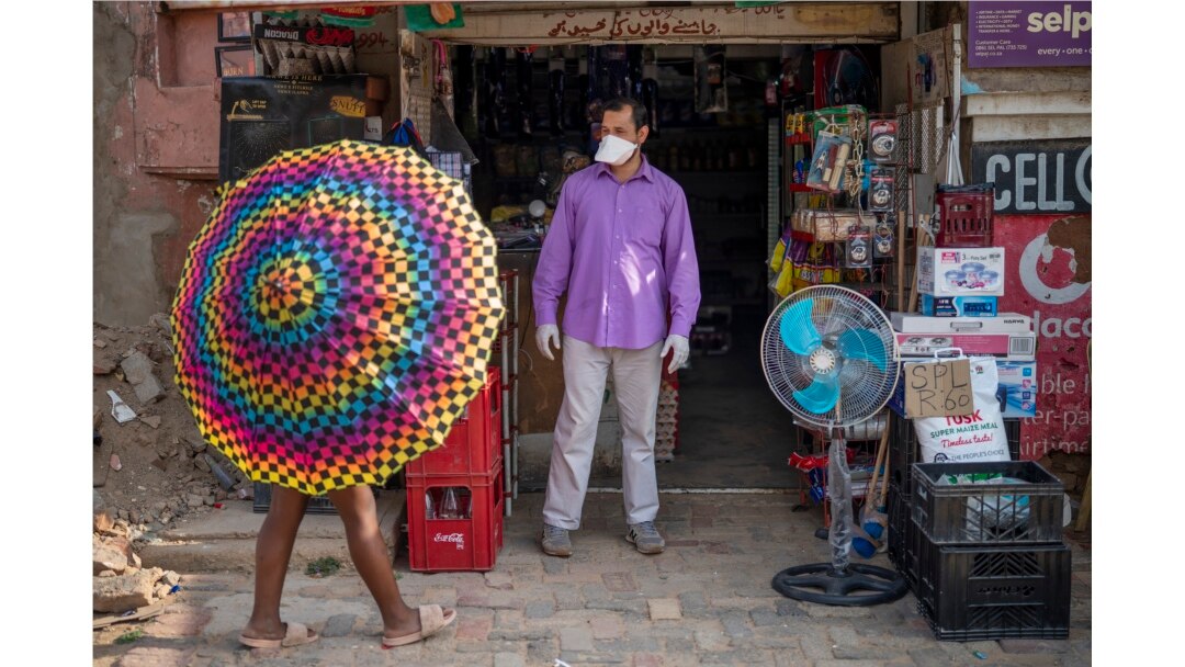 Iftikhar Ahmad, un comerciante pakistaní, es uno de los pocos que lleva una máscara en el municipio de Diepsloot, al norte de Johannesburgo, Sudáfrica.