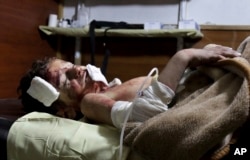 FILE - This photo provided by the Unified Medical Bureau of Eastern Ghouta, an opposition activist-run civil society organization, which has been authenticated based on its contents and other AP reporting, shows a boy receiving treatment at a hospital in Ghouta, an opposition-controlled suburb of the capital, Damascus, Nov. 6, 2016. The locally run Education Directorate said government forces struck a school in Ghouta during the first recess of the day. It said more than 25 children were wounded and at least six were killed.