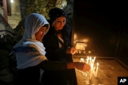 Iraqi Christians light candles after a Christmas Eve Mass in St. Joseph's Church in Baghdad, Iraq, Dec. 24, 2017.