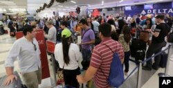 Passengers wait in line at the Delta airlines counter in terminal 2 at the Fort Lauderdale-Hollywood International Airport in Fort Lauderdale, Fla., Jan. 7, 2017.