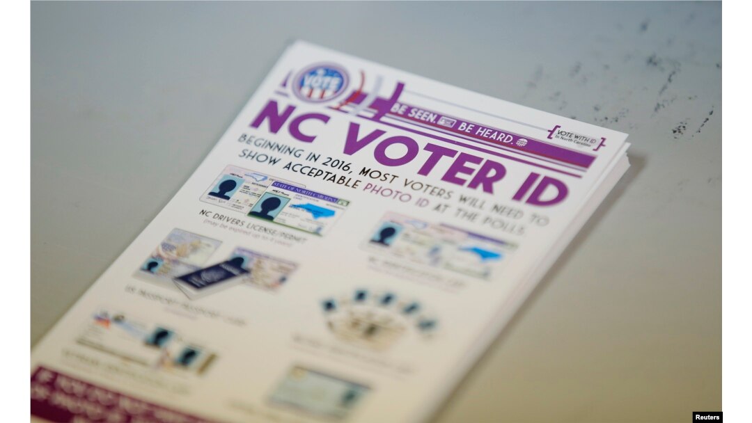 FILE - A pile of government pamphlets explaining North Carolina's controversial "Voter ID" law sits on table at a polling station.