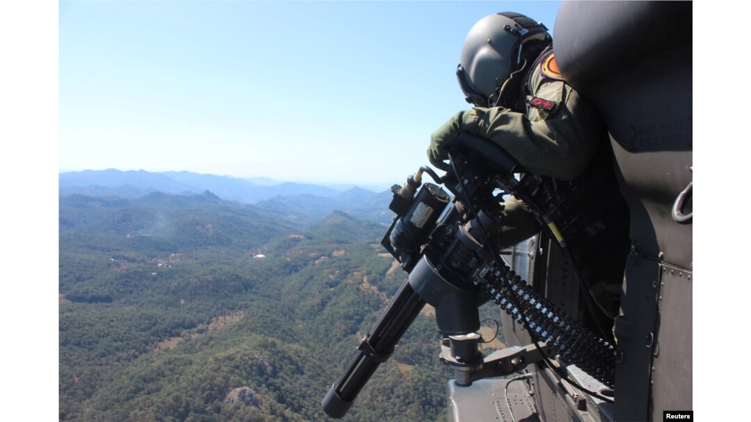 A soldier flies in a helicopter as he patrols at a poppy plantation used to make heroin during a military operation in the state of Sinaloa, Mexico, March 18, 2017.