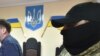FILE - A masked police officer escorts a defendant out of a courtroom in the southern Ukrainian city of Kherson, May 17, 2018.