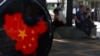 FILE - Residents rest near a map of China near a shopping district in Beijing on May 8, 2021.
