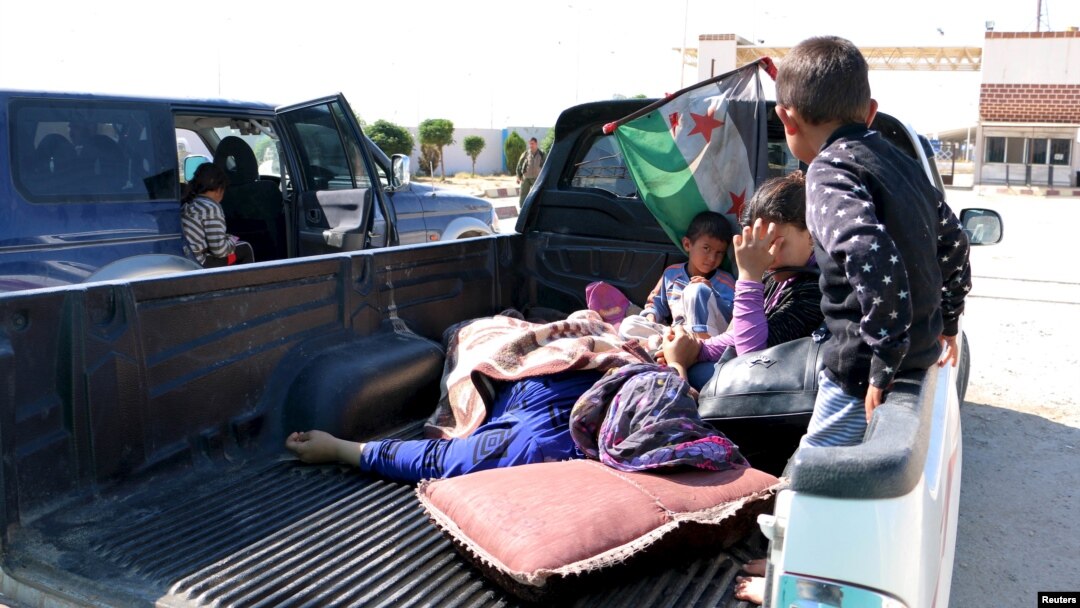 Civilians, who were wounded by what activists said was violence caused by Islamic State fighters in Kobani, wait with their relatives to cross into Turkey at the Syrian-Turkish border crossing of Tel Abyad, Syria June 25, 2015. 