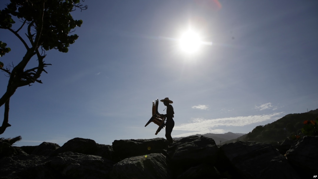 Douglas Yriarte lleva sillas de alquiler para turistas en la playa La Última, en La Guaira, Venezuela, el 23 de octubre de 2020.