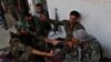 U.S.-backed Syrian Democratic Forces fighters talk to each other at their position where they were battling Islamic State militants, on the front line on the western side of Raqqa, northeast Syria, July 17, 2017.