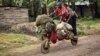 People ride with their belongings on a wooden bicycle as they flee from renewed fighting between Congolese army and M23 rebels near the eastern Congolese city of Goma, July 24, 2012.