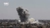This frame grab from video provided Aug. 13, 2017, by the Ghouta Media Center, a Syrian activist media group, shows smoke and debris rising after a Syrian government ground-to-ground rocket strikes the opposition-held town of Ain Terma, in the Eastern Ghouta suburb of Damascus, Syria. 