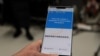 Yu Hong, Beijing Olympics Organizing Committee tech chief, holds a mobile phone showing a translation function on the 2022 Winter Olympic Games official app "MY 2022," in Shougang Park in Beijing on Jan. 20, 2022. 