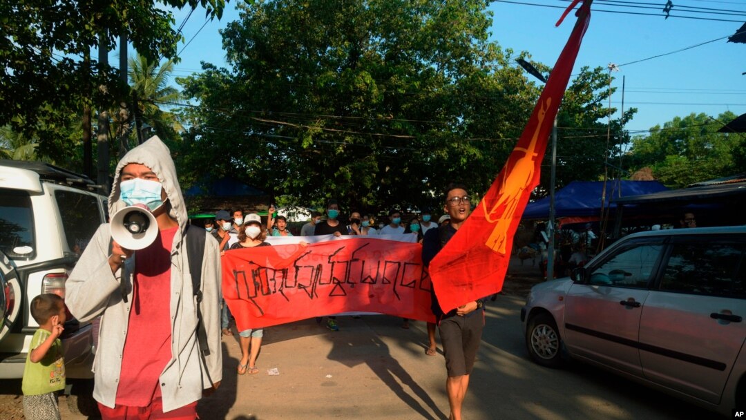 Manifestantes marchan para protestar contra el golpe militar de febrero en Rangún, Myanmar, el domingo 11 de abril de 2021. La pancarta dice: "Absolutamente no dictadura".