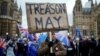 FILE - A pro-Brexit protester holds a banner as anti-Brexit protesters demonstrate outside the Houses of Parliament, ahead of a vote on Prime Minister Theresa May's Brexit deal, in London, Britain, January 15, 2019. 