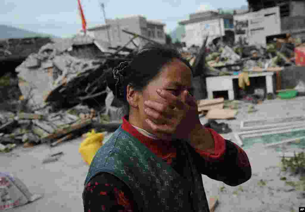 A village woman reacts after her house was damaged by an earthquake in Lushan county, Ya'an, southwest China's Sichuan province, Apr. 20, 2013.