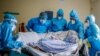FILE - A medical team rolls a coronavirus patient from a bed onto a stretcher in the COVID-19 intensive care unit at Kenyatta National Hospital, in Nairobi, Kenya, April 14, 2021.