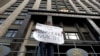 FILE - A lone protester demonstrates against the original NGO foreign agent law, outside the Duma, Russia's lower house of parliament, in Moscow, Russia, July 6, 2012. The placard reads "Tightening the NGO law speaks to the paranoia of authorities."