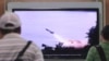 FILE - People watch a TV news program showing the missile launch conducted by North Korea.