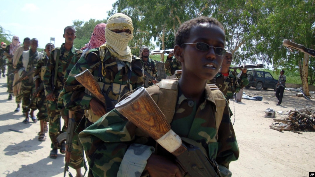 Wapiganaji wa al-Shabaab wakiwa katika mazoezi yao ya kivita, wakiongozwa na mtoto mdogo katika kitongoji cha Suqaholaha, karibu na Mogadishu, Somalia, Januari. 1, 2010. 