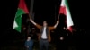 Manifestante agita bandeiras iraniana e palestiniana durante protesto anti-Israel em Teerão, Irão, 14 abril 2024 I