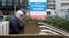 FILE - A person wearing personal protective equipment walks outside St Thomas' Hospital in London, Dec. 12, 2021.