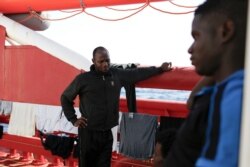 Mouctar Diallo, from Guinea, stands by hanging clothes aboard the Ocean Viking humanitarian rescue ship, in the Mediterranean Sea, Sept. 13, 2019.