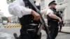 Armed police officers hold guns as they stand on Downing Street, in central London, Aug. 29, 2014. 