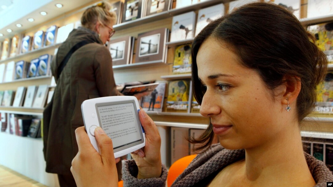 FILE - A woman reads an E-Book at the Book Fair in Frankfurt, central Germany. 