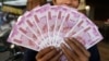 FILE - An Indian man displays new currency notes of 2000 Indian rupee in Ahmadabad, India, Nov. 11, 2016. 