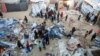 Palestinians inspect the damage at a tent camp sheltering displaced people, following an Israeli strike in Khan Younis on Dec. 18, 2024.