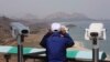 A South Korean tourist uses binocular to look at the Diamond Mountain in North Korea from the Unification Observation post in Goseong, South Korea, April 7, 2017.