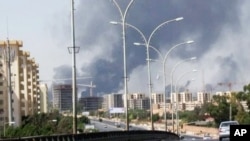 Smoke rises from the direction of Tripoli airport, July 13, 2014.