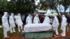 FILE - Health officials wearing personal protection equipment prepare to bury a coronavirus victim, in Ndalu, Bungoma county, Kenya, July 13, 2020. 