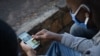 A man looks at his smartphone in Kigali, Rwanda, May 18, 2020, showing an article about the arrest of Felicien Kabuga, a fugitive wanted over the 1994 Rwandan genocide, who was arrested by French police May 16, 2020, in a Paris suburb. 