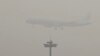 An Air China passenger plane prepares to land at the Beijing Capital International Airport as the capital of China through heavy smog on Wednesday, Dec. 21, 2016.