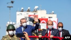 Turkish President Recep Tayyip Erdogan, left, and Turkish Cypriot leader Ersin Tatar, right, take part in a parade in the northern part of Cyprus' divided capital Nicosia, in the self-declared Turkish Republic of Northern Cyprus, July 20, 2021. 